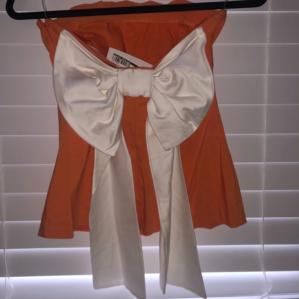 Orange and white tank top with white now on back